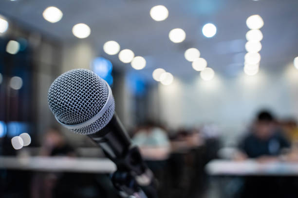 istock Microphone over the blurred business forum Meeting or Conference Training Learning Coaching Room Concept with noise, Blurred background. 1053256728