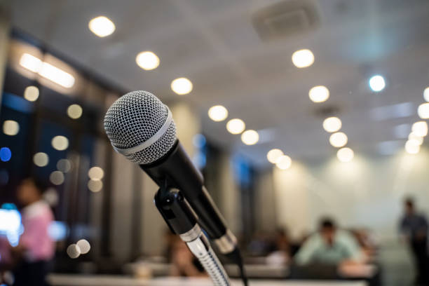 istock Microphone over the blurred business forum Meeting or Conference Training Learning Coaching Room Concept with noise, Blurred background. 1053256742