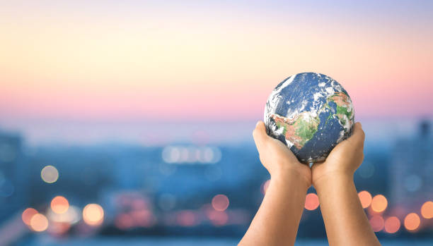 Sustainable community concept Human hands holding earth global over blurred city night background. Elements of this image furnished by NASA responsible business stock pictures, royalty-free photos & images