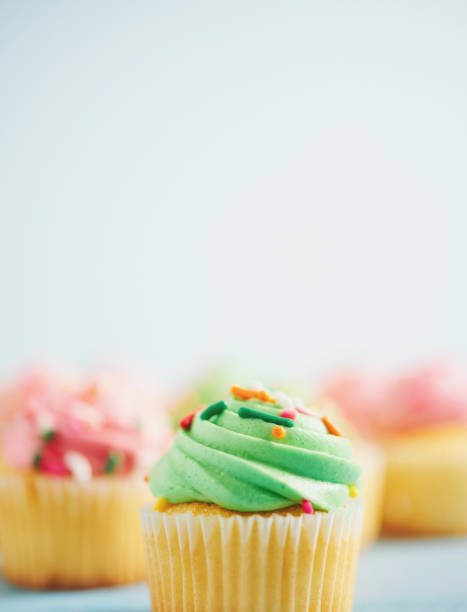 Pastel cupcake background in green and pink Pastel cupcakes in pink and green birthday cake green stock pictures, royalty-free photos & images