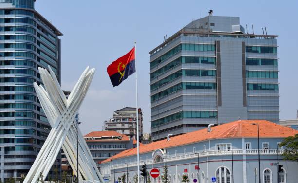 Luanda, Angola: unknown soldier memorial in front of the colonial building of the Central Post Office and flanked by two buildings of the state oil company Sonangol - Flag of Angola - monumento ao soldado desconhecido - Avenida Marginal, Largo Pedro Alexandrino da Cunha, 19th century Portuguese governor and naval officer.