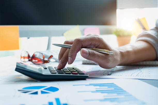 istock Businessman working with calculator, business document and laptop computer notebook in office. bookkeeper making calculation. Savings, finance 1053295692