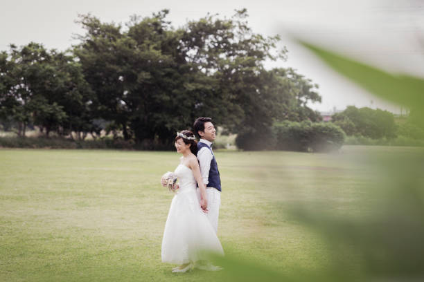 istock Bride and groom standing back to back in the green field 1053299148
