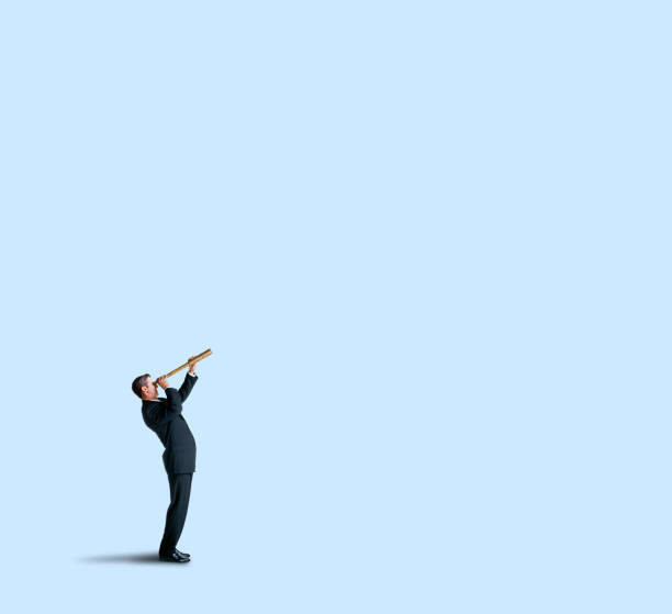 istock Businessman Looks Through Spyglass On Blue Background 1053311894
