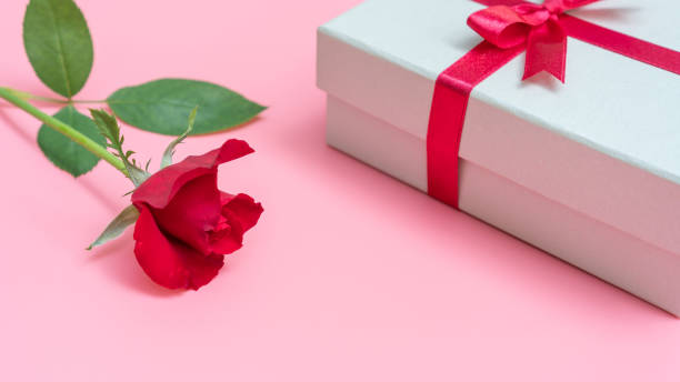 istock Red rose and gift box on a pink background. 1053312272