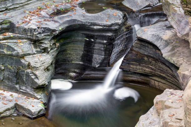Narrow Channel Water carves a narrow channel through layerd  rock in the gorge at New York's Watkins Glen State Park. watkins glen stock pictures, royalty-free photos & images