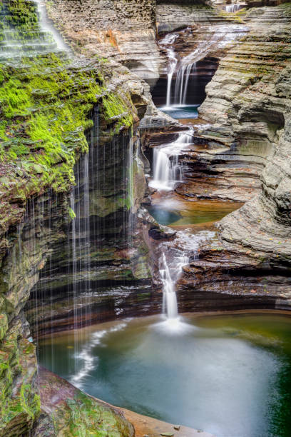 Rainbow Falls and the Triple Cascade Rainbow Falls flows down a rocky gorge wall alongside the Triple Cascade at New York's Watkins Glen State Park. watkins glen stock pictures, royalty-free photos & images