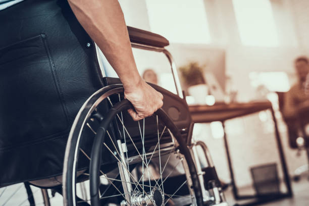 istock Close up. Disabled Man on Wheelchair in Office. 1053318130