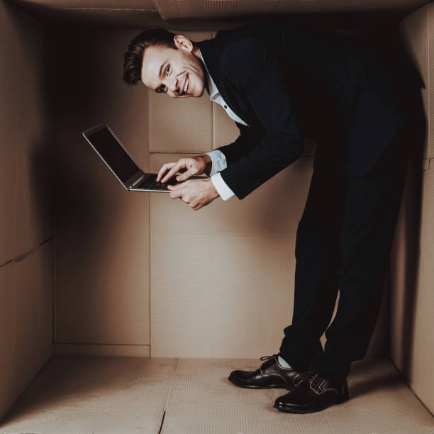 istock Young Businessman with Laptop in Cardboard Box. 1053320962