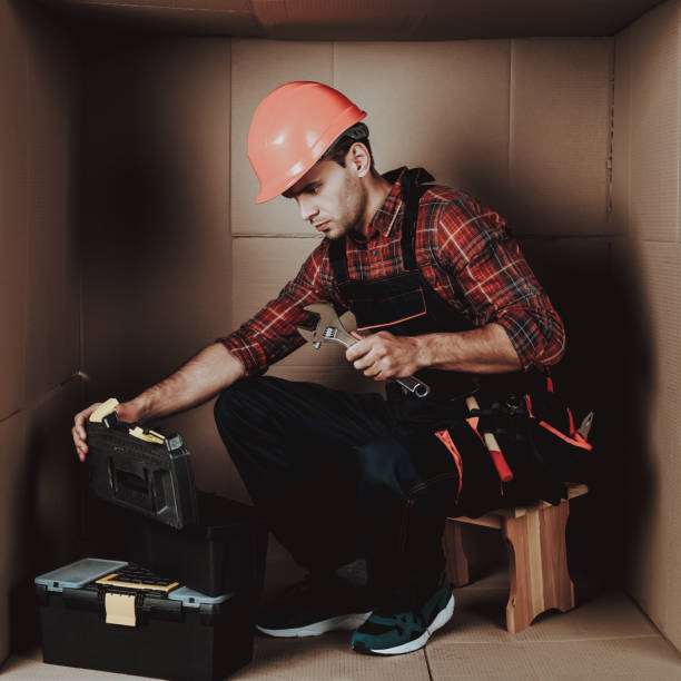 operaio in casco arancione seduto in scatola di cartone. - engineer environment orange manual worker foto e immagini stock