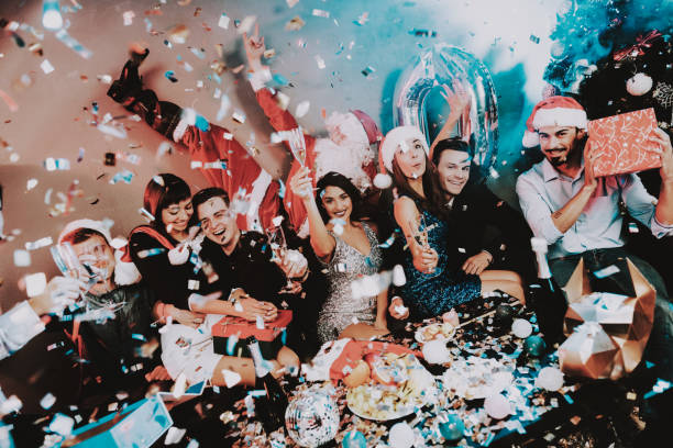 istock Young Happy People Celebrating New Year at Table. 1053322396