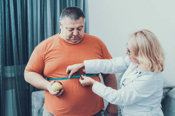 fat man avec médecin en blouse blanche dans la chambre grise. - torso male white men photos et images de collection