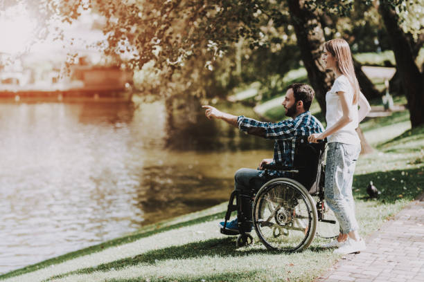 istock Disabled Man on Wheelchair with Girlfriend in Park 1053322994