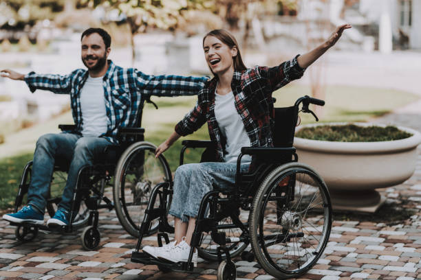 istock Disabled People on Wheelchairs Have Fun in Park. 1053323042