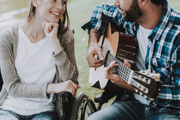 istock Disabled Man on Wheelchairs Playing Guitar in Park 1053323044