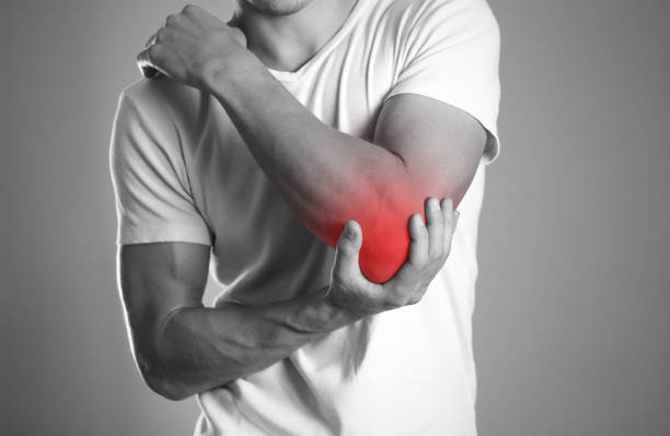 a man holding hands. pain in the elbow. the hearth is highlighted in red. close up. isolated background - elbow imagens e fotografias de stock