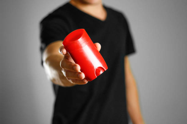 istock The guy is holding a red deodorant. Shows a deodorant. Close up 1053331040