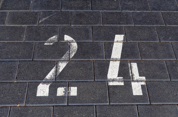 istock Number 24 on a dark path with gray black cobblestones with white numerals 1053335492