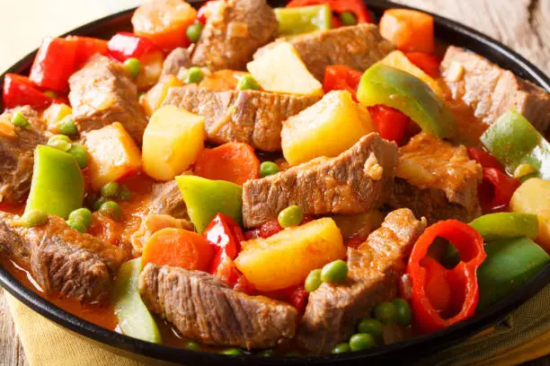Philippine cuisine: kaldereta beef with vegetables close-up on a plate. horizontal