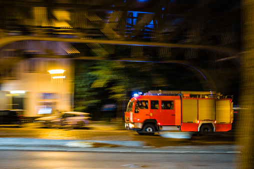 Berlin, Germany - October, 10, 2018: night in Berlin Kreuzberg, an emergency ambulance drives by, motion blur