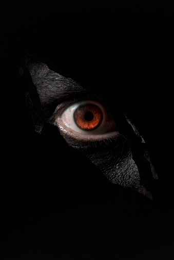 Spooky eye looking through a hole. Halloween theme.