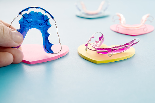 Dental retainer orthodontic appliance on the blue background.