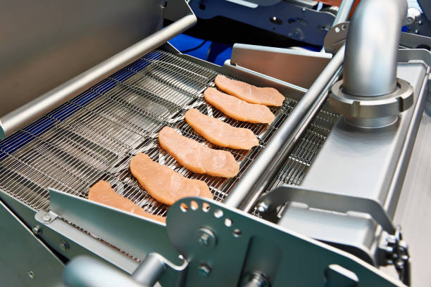 istock Pieces of meat in machine dry breading 1053353992