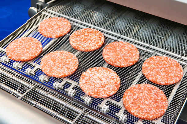 istock Pieces of minced meat in machine wet breading 1053354010