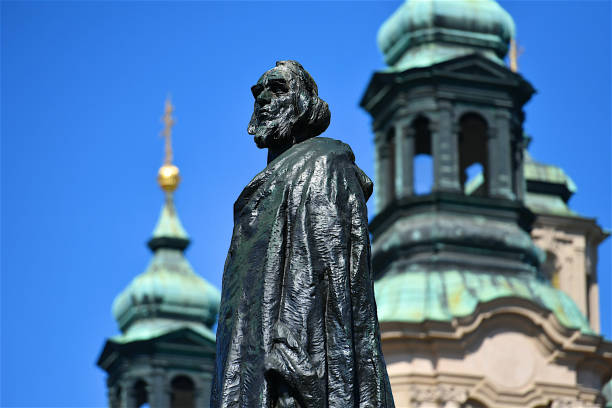 Statue of Jan Hus in Prague Jan Hus statue and St nicolas's church towers in the background, religion,art,travel,architecture st nicholas church prague stock pictures, royalty-free photos & images