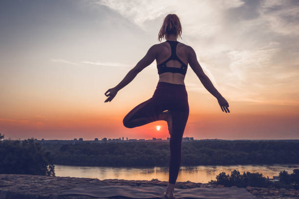 istock Woman practicing yoga outdoors. Summer sunset 1053364088