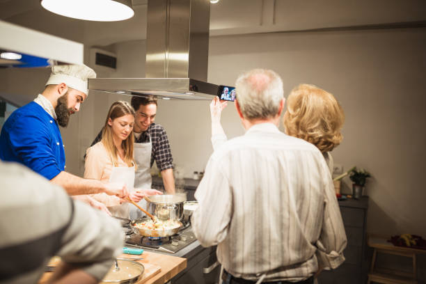 istock Chef is supervising attendees of cooking class while they are making meals 1053372530