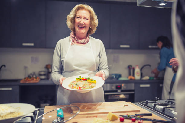 istock Senior lady, attendee of cooking class with risotto 1053372568