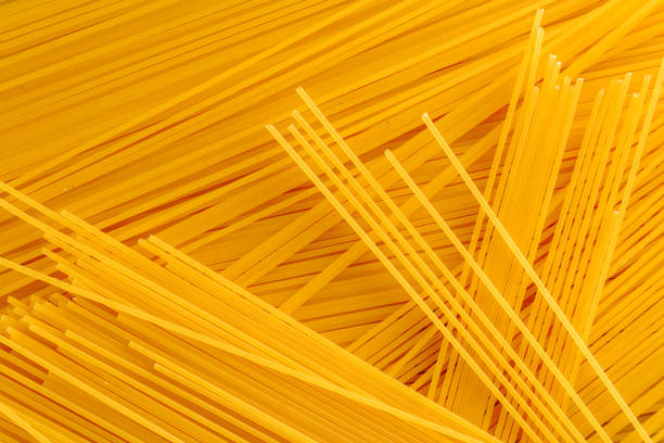 istock spaghetti as a background. Yellow paste, lays a bunch, abstracti 1053376114