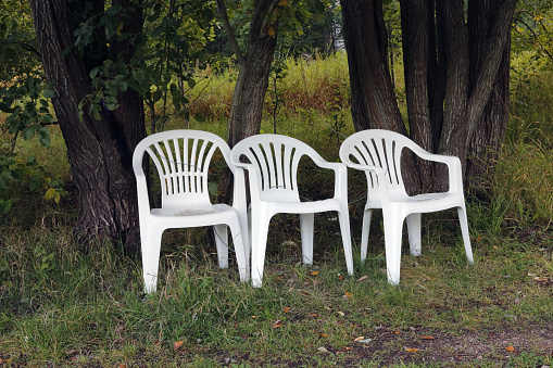 three white plastic chairs outdoors