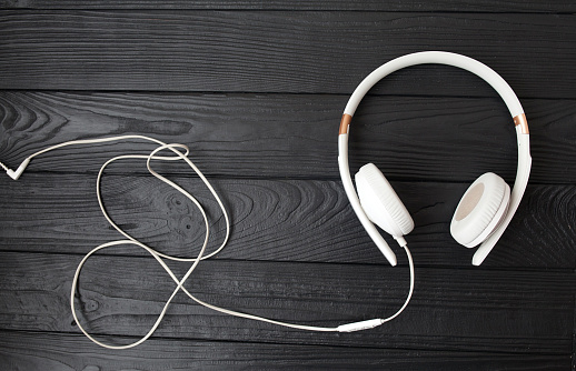 An elegant image of a blue wireless headset, shot in a lightbox against a red background