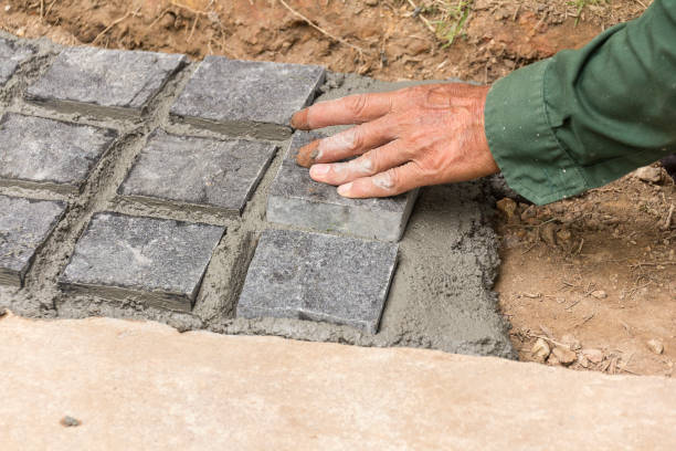 istock Hand of mason worker making sidewalk pavement with stone blocks 1053392912