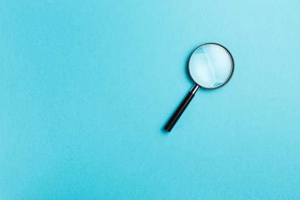 istock Magnifying glass on blue background. Top view. Flat lay. Copy space. Minimal creative concept. Blue background in pastel colours 1053396314