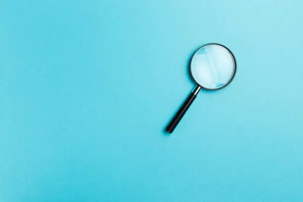 Photo of Magnifying glass on blue background. Top view. Flat lay. Copy space. Minimal creative concept. Blue background in pastel colours