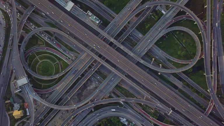 Drone footage of top view of Highway road junctions. The Intersecting freeway road overpass the eastern outer ring road of Bangkok, Thailand.Zoom out shot