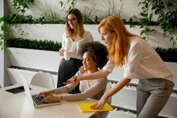 istock Cheerful professional multiracial women working in modern office 1053403798