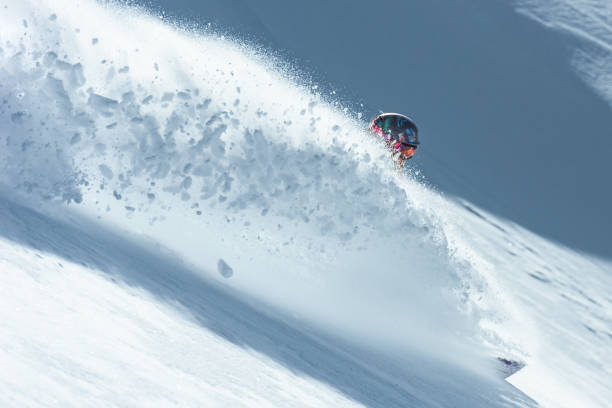 istock Snowboarder making a huge snow splash in fresh powder snow 1053409376