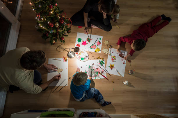istock Young family celebrating Christmas making decorations 1053410226
