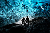 Silhouette of couple inside glacial cave