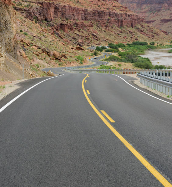 istock Winding Utah road, mountains and river in background 1053415058