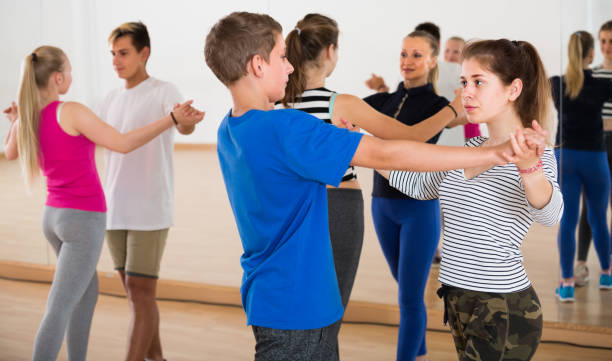 istock Group of concentrated teen dancing tango in dance studio 1053416576