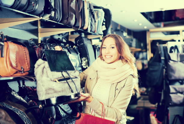 istock Smiling female choosing bag among assortment 1053417266