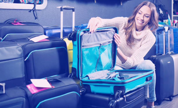 istock Smiling female purchasing travel suitcase 1053417336