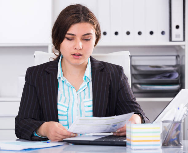 istock Office manager woman is reading documents about the transaction 1053418040