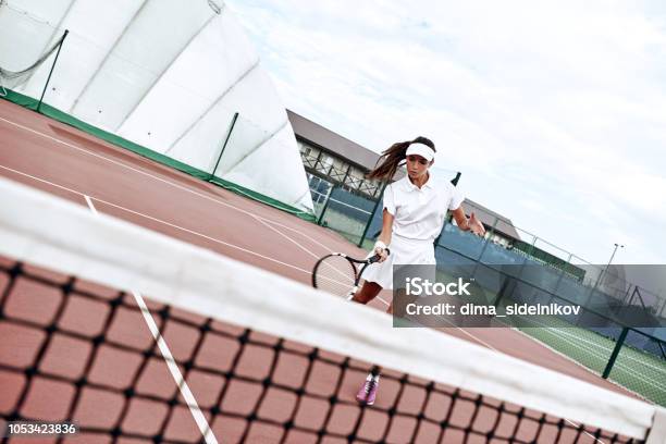 Cintura Para Arriba Retrato De Dama Positivo Tener Tenis Coinciden En Día Soleado Ella Va Junto A La Red Y Elevación Del Brazo Con La Raqueta Para Golpear La Bola Juego Activo Como Especie Del Concepto Ejercicio Foto de stock y más banco de imágenes de Adulto