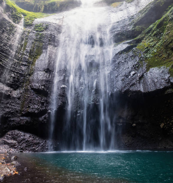 istock Majestic waterfall flowing on rocky cliff in tropical rainforest 1053426614